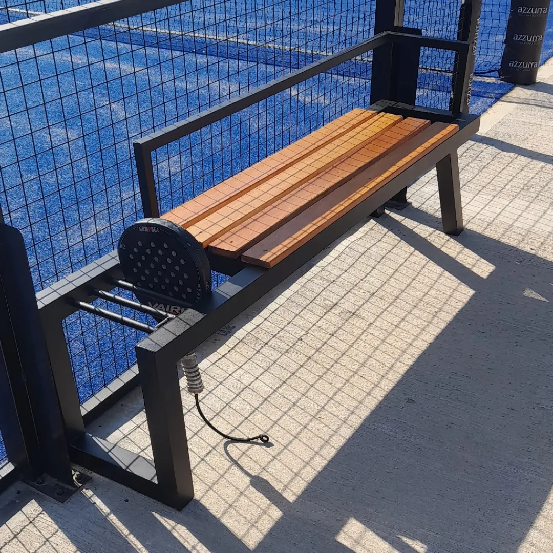 Banco de madera y hierro en cancha de pádel